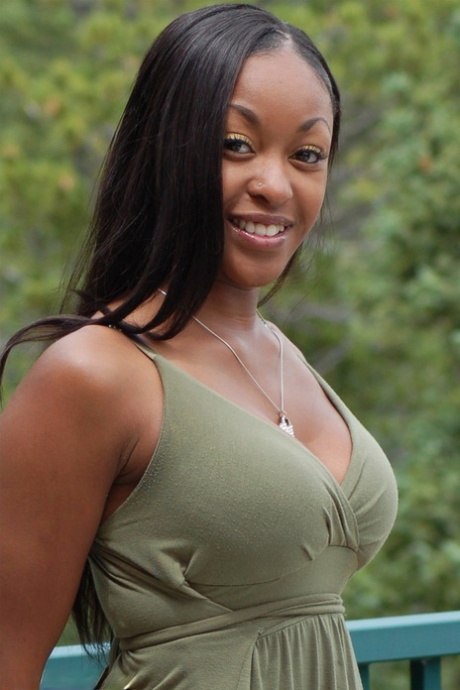 Ebony amateur Amber releases her big tits from a long dress on a balcony