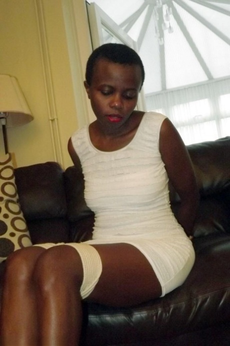 Black female is left tied and cleave gagged in a white dress on a leather sofa