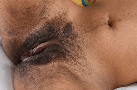 Ebony in glasses Olivia Green reveals her hairy vagina and poses in a solo
